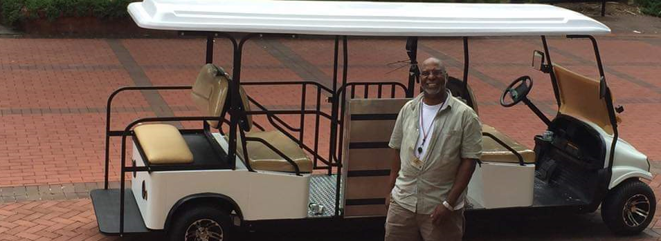 Accessible Transportation Specialist, Dexter Taylor, standing in front of the accessible golf cart