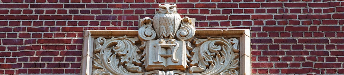 Photo of a stonework owl and book emblem on the outside Eppes Hall 